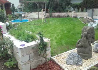Garteneinfassung mit Natursteinelementen und Statuen